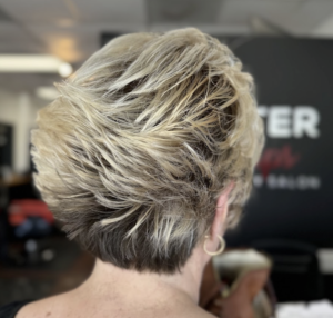 Short, textured blonde hairstyle with layered back.